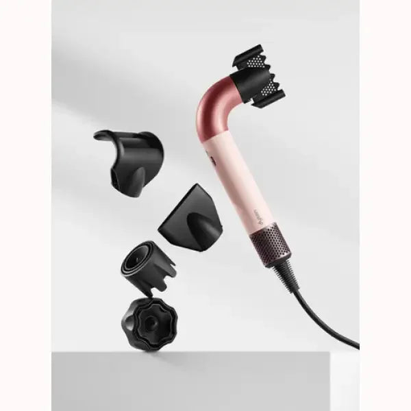 Asciugacapelli Dyson rosa con accessori neri per diverse acconciature professionali