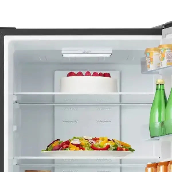 Interno di frigorifero HISENSE con torta, insalata colorata e bottiglie verdi