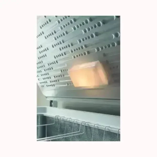 Dettaglio interno del congelatore INDESIT con sistema di raffreddamento e griglia metallica