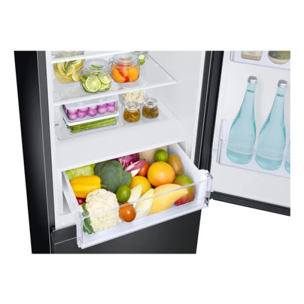 Interno di frigorifero combinato Samsung con ripiani e cassetto verdure pieni di frutta e verdura fresca