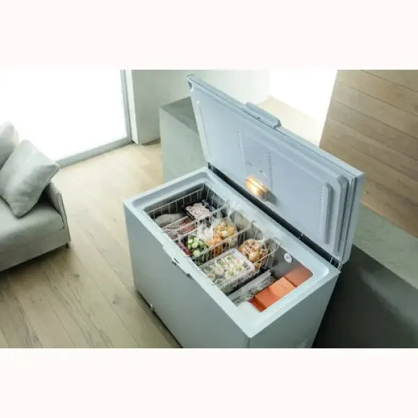 Congelatore a pozzetto Whirlpool aperto con cesti organizzati e alimenti surgelati in salotto moderno