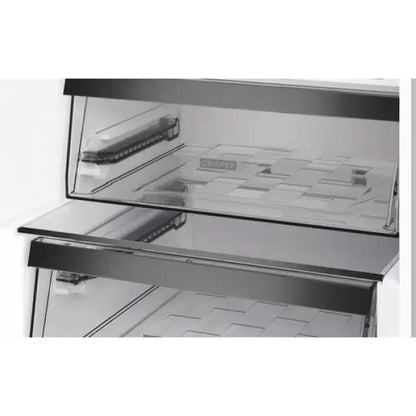 Dettaglio interno del frigo combinato Whirlpool con ripiani in vetro trasparente e cassetto crisp