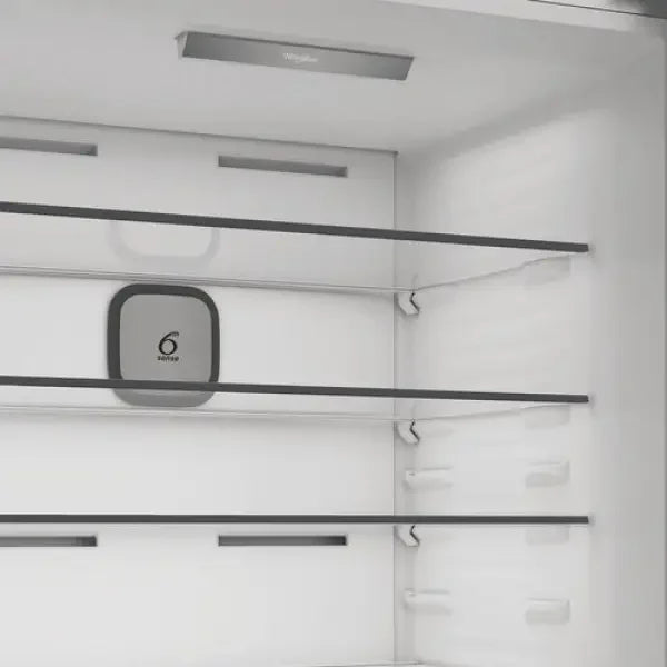 Interno bianco del frigorifero Whirlpool con ripiani in vetro trasparente e sistema Fresh Control