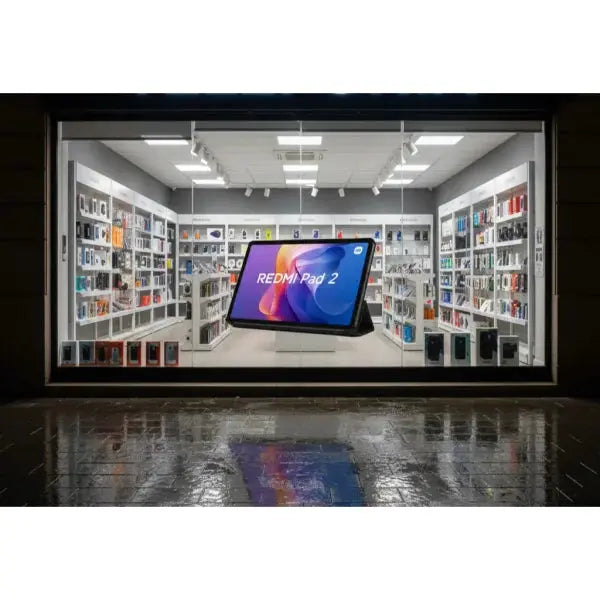 Vetrina di negozio con il tablet Xiaomi Redmi Pad 2 in evidenza tra vari accessori tecnologici